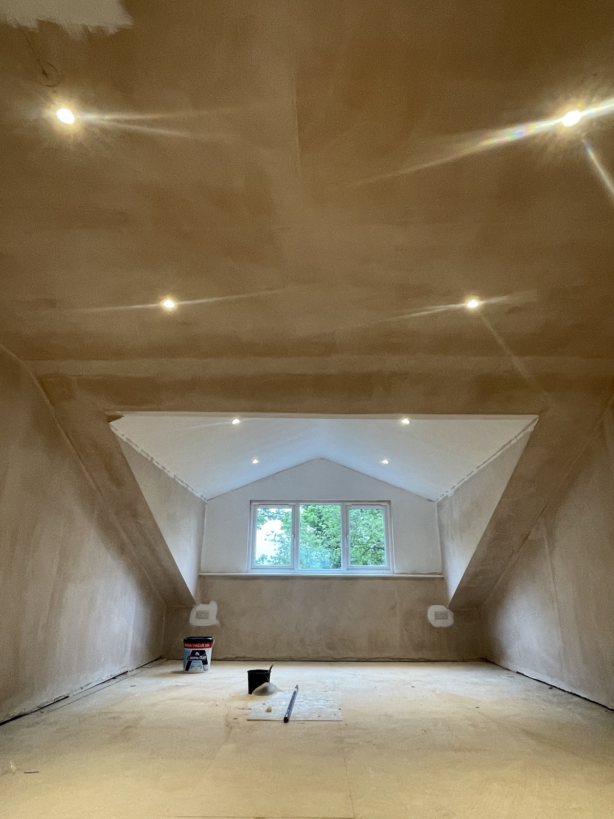 A freshly plastered loft room with new recessed downlights fitted
